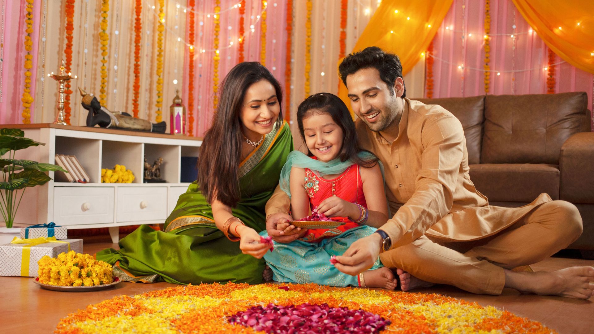 Family creating rangoli of flowers
